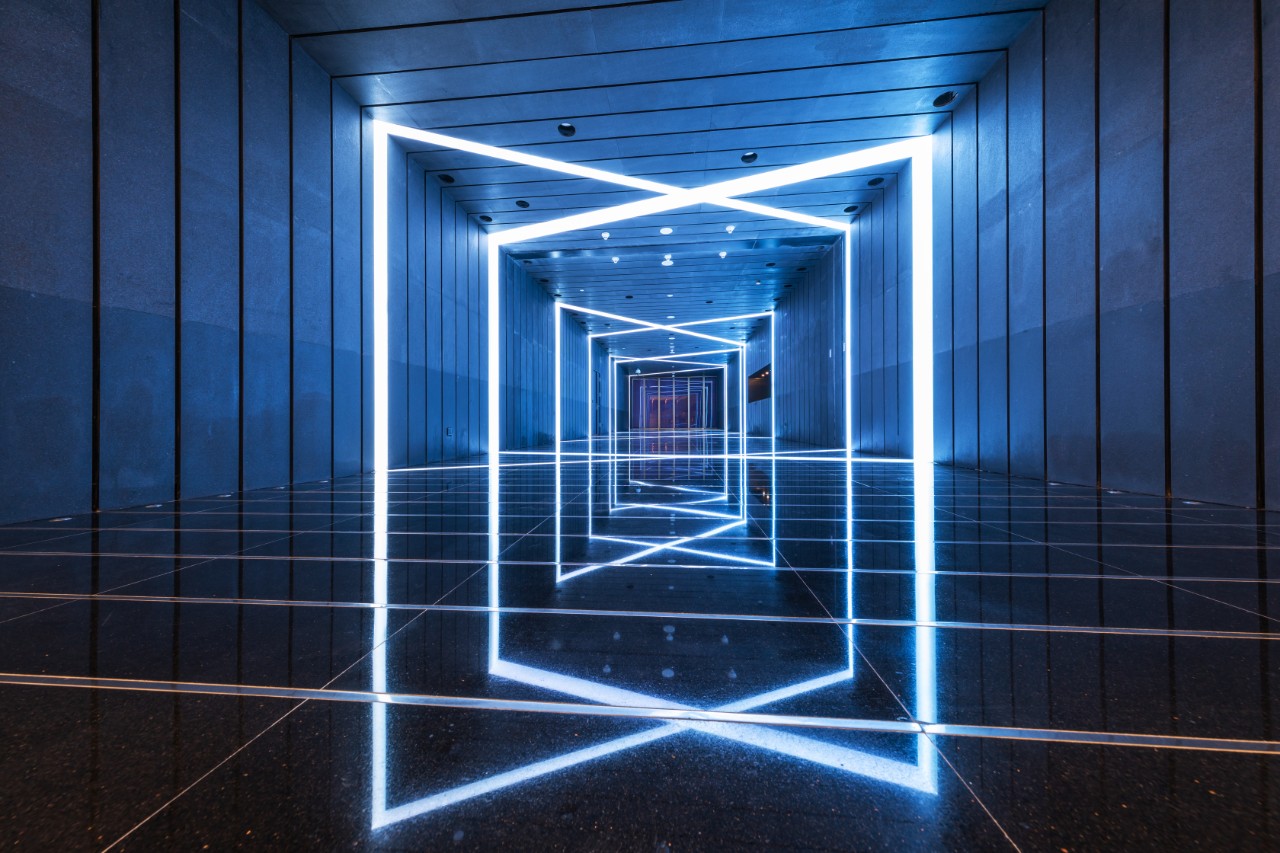 a metal paneled hallway with a light fixture that is in the shape of an x